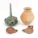 A collection of antiquities, comprising a Roman glass bottle with three applied flower motifs, 19cm,