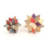 Two pin stuck patchwork pin holders, comprising a hexacontagon with pin stuck and beadwork edges,