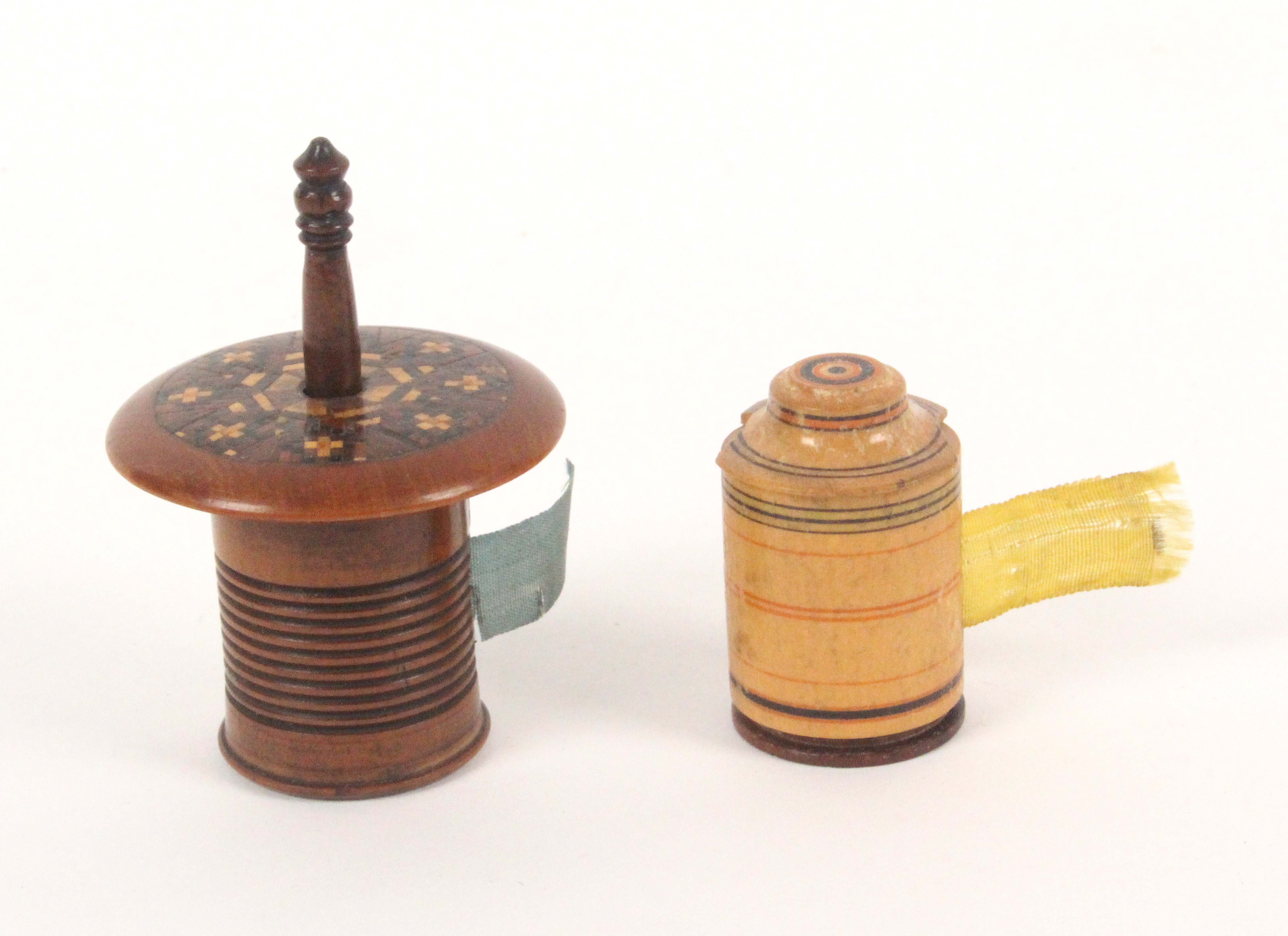 Two Tunbridge ware tape measures, comprising a white wood cylinder example with line painted