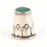 A silver thimble by Georg Jensen, the frieze with tulip form motifs below a green stone top, stamped