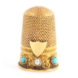 An attractive Victorian gold thimble the leaf scroll and flower engraved frieze set with two