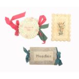 Three Bristol card type needle books comprising a circular example, needlework border and