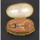 A mid 19th Century sewing companion for a child or doll, the gilded base with leaf scroll decoration