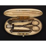 A late 19th Century oval ivory cased etui, flush fitted with an engraved silver gilt needle case,