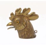 A brass novelty vesta case, in the form of a cockerel's head, glass eyes, hinged beak, 5cm.
