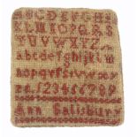 A sampler form pin card, worked in red with upper and lower case alphabets and numerals and