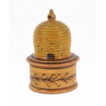 An early painted Tunbridge ware white wood pin poppet in the form of a bee skep, the circular box