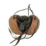 A mid 19th Century green silk draw-string purse contained within a natural walnut, 4cm high