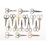 Eighteen pairs of 20th Century scissors, mostly steel with decorative arms and loops, largest 10.