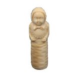 A fine 19th Century French ivory needle case in the form of a swaddled baby, wearing a bonnet and