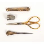 Four sewing tools, comprising a French gold engraved needle case of oval section, 6.5cm, a