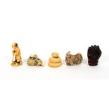 Four netsuke and a figure, comprising a carved wooden netsuke as a hand enclosing a figure, 5cms,