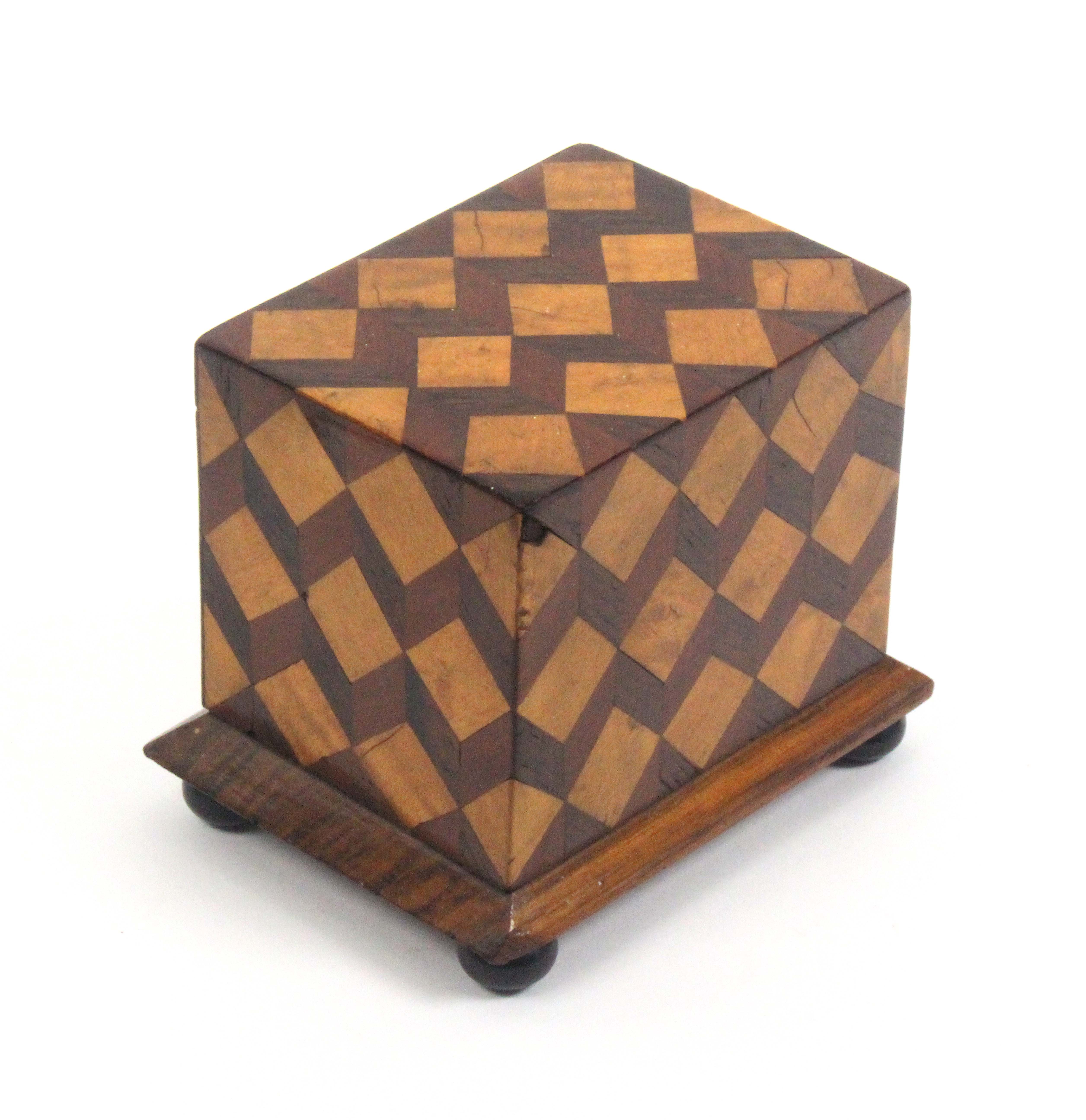 A documentary money box, decorated in cube pattern of rectangular form on a chamfered plinth base