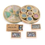 A 19th Century French circular cardboard bead box containing seven glass top circular bead boxes, of