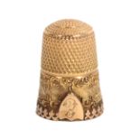 An attractive 19th Century gold thimble, the part frosted frieze with leaf scroll edges divided by a