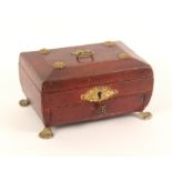 A Regency red leather covered sarcophagal form small sewing box, raised on gilt paw feet with gilded