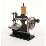 A 1930’s period miniature sewing machine for a child, unmarked, 11.5cms wide.