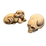 Two early 20th Century ivory netsuke, comprising a skull, 4cm, and a hound at rest, 4.5cms.     (2)