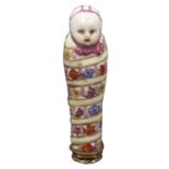 A 19th Century German porcelain needle case in the Meissen style in the form of a swaddled baby,