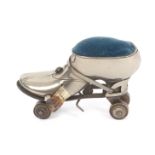 A scarce novelty combination tape measure and pin cushion in the form of a roller skate, engraved to