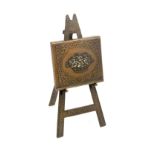 A brass Avery needle packet case ‘The Easel’, leaf decorated easel with basket of flowers folio,