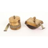 Two metal novelty tape measures, comprising a curved form brass desk blotter, the complete printed