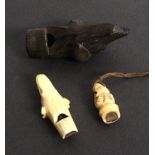 Three 19th Century whistles all as dogs heads, comprising a wooden example, repair to old split,