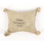 A pin stuck tassel corner silk pin cushion dated ‘1736’, of inward curving rectangular form the