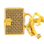 An unusual early 19th Century needle book, the covers in yellow silk with panels of split straw