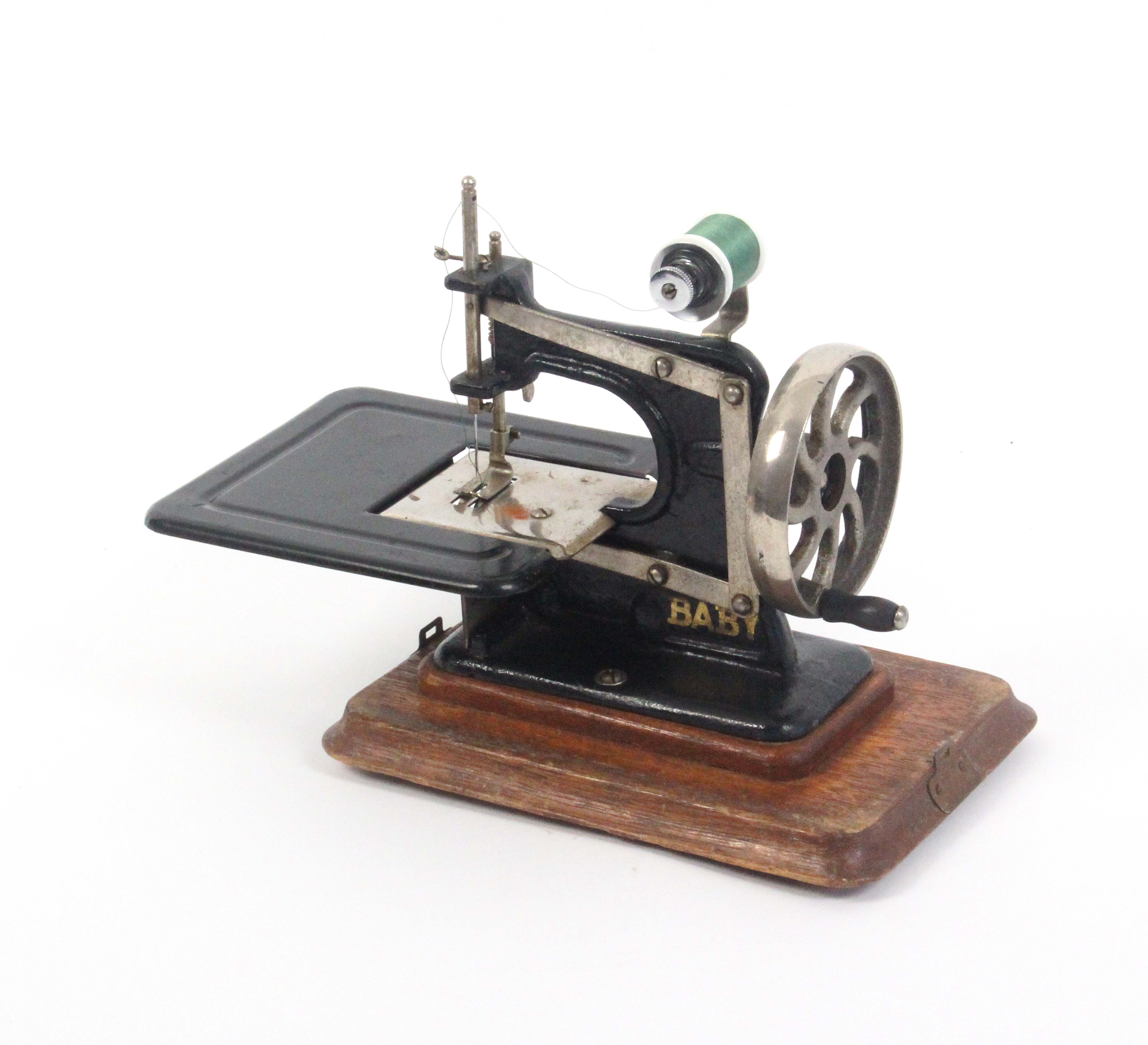 An early 20th Century sewing machine ‘Baby’, in gilt on black, wooden plinth base, additional - Image 4 of 4
