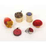 Six pin cushions and emeries, comprising a 19th Century ivory example of basket form, 2.8cm, a