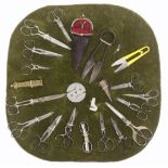 A radiating display of scissors and related items, on green velvet including five pairs of steel