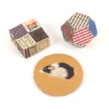 Three pin cushions, comprising a good patchwork example with pin stuck decoration, 4cms, a