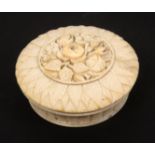 A 19th Century French carved ivory circular bonbonniere, the domed lid carved with a circular