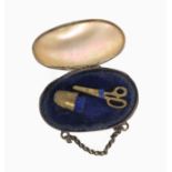 A 19th Century miniature etui for a doll, contained in a mother of pearl egg with gilt hinge mount