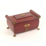 A good Regency red leather covered sewing box of sarcophagal form, raised on gilded paw feet with
