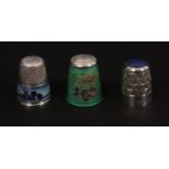 Three 20th Century silver thimbles, comprising a continental example with Delft style enamel frieze,
