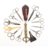 Thirteen pairs of scissors, and a brass sheath comprising a stork pair, a pair with lion head mask