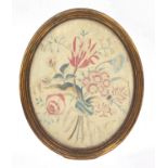 Three framed needleworks and a print, comprising an oval silk embroidered floral bouquet, some loss,