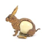 A metal and celluloid novelty tape measure in the form of a seated hare, the complete printed tape