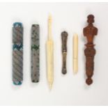 Six needle cases, comprising an early 19th Century figural carved coquilla nut example, loss to
