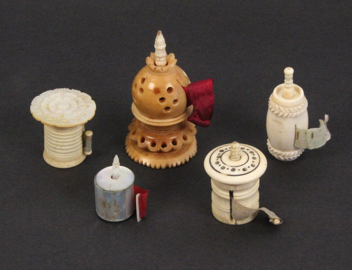 Five tape measures, comprising a 19th Century ivory barrel form example, tape a/f, 4cms, a mother of