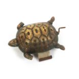 A brass novelty tape measure in the form of a turtle, the complete printed tape in ins. only and