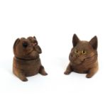 An amusing pair of early 20th Century Black Forest carved wooden ink wells, one as the head and paws