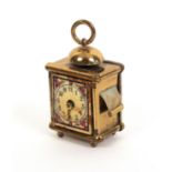 A scarce gilt brass novelty tape measure in the form of a mantel clock, below a bell and ring,