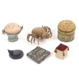 Six pin cushions, comprising a pin stuck velvet spider, 11cms, a printed cardboard cylinder example,