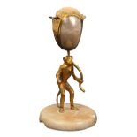 A 19th Century Palais Royal style pin cushion in the form of a gilded standing monkey, holding a