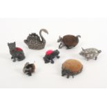 Seven metal animal form pin cushions, comprising a seated cat, 4.6cms, a standing pig, 5.5cms, an