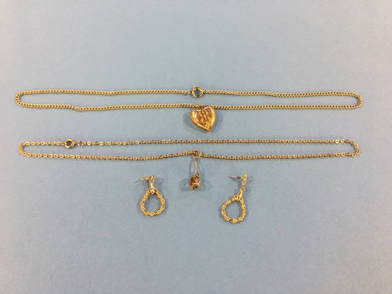 A 9ct gold heart pendant, a 9ct gold mounted pendant together with two yellow metal chains and a