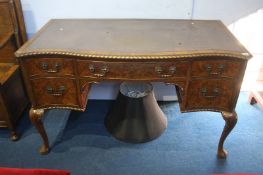 A walnut serpentine front desk, with leather inset top